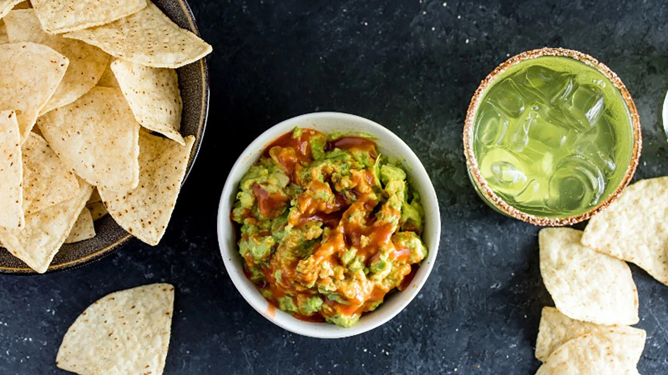 Guacamole with hot sauce and tortilla chips
